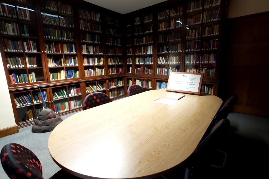 Centre for Arthurian studies wide lens show table with bookshelves