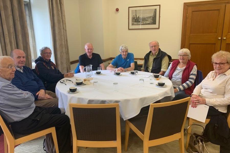 a group of the 60/70's former Bangor students in a reunion around a circular table