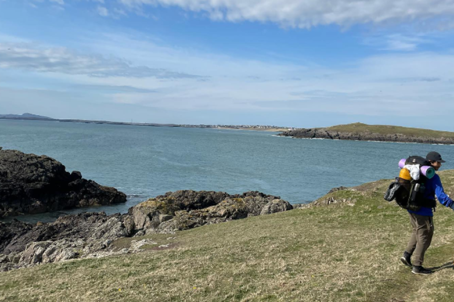 An image of Christian walking on a costal path 