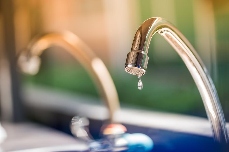 Dripping gold tap with blurred background