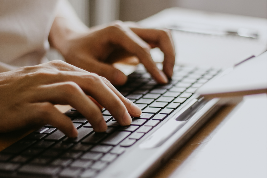 Close up of a person's hands typing on a computer keyboard