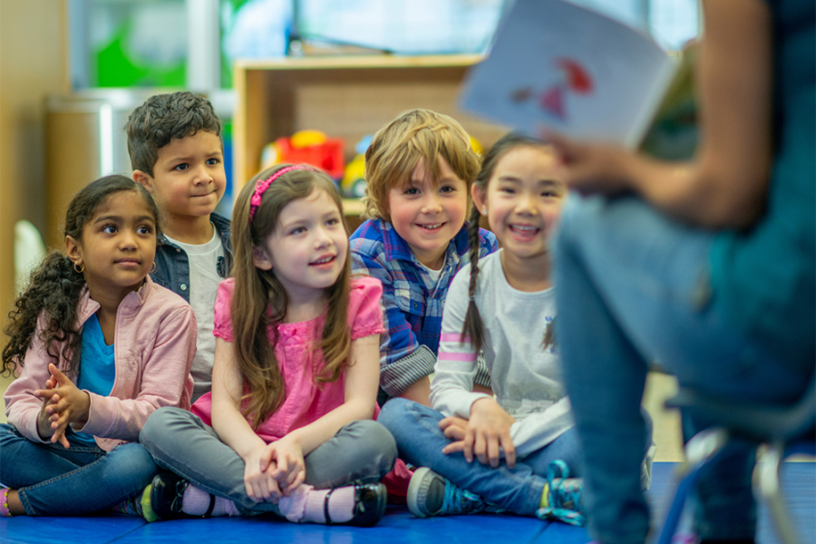 Children sitting in a classroom, learning from the teacher