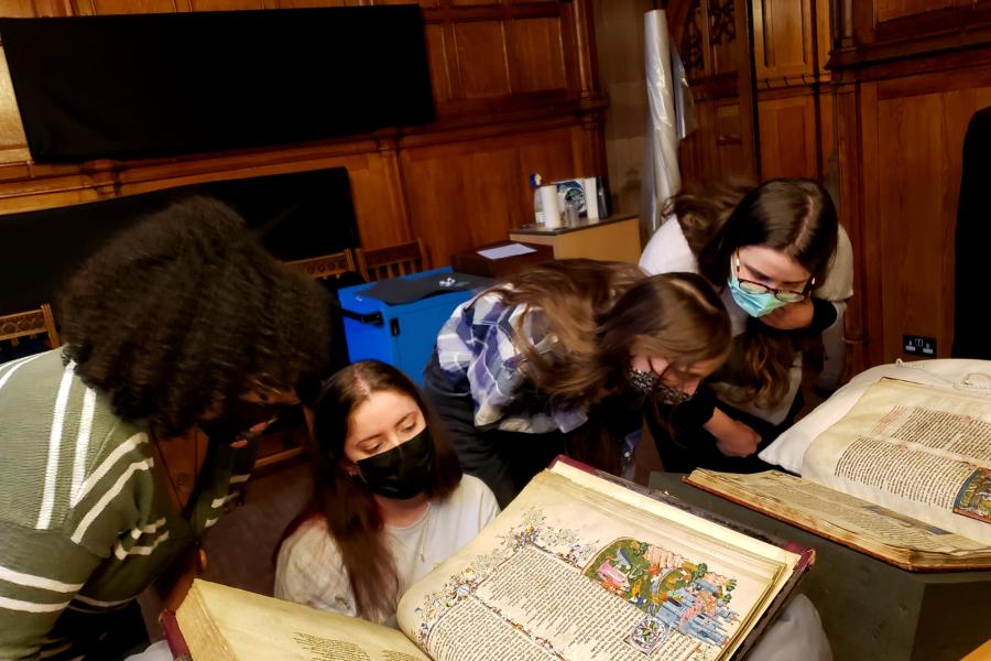 Four students looking at medieval manuscripts