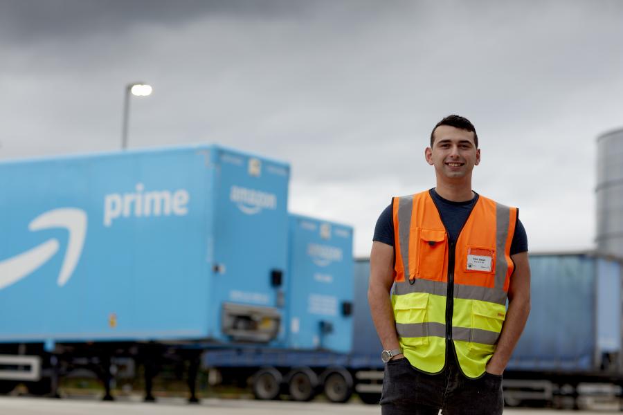 Graduate stood near an Amazon Prime lorry