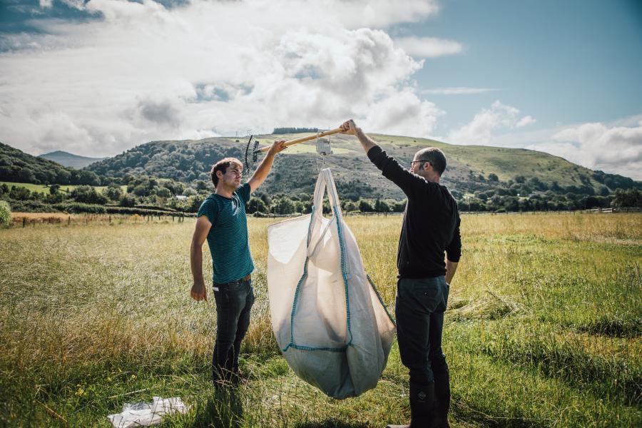 2 researchers weighing produce in field in Snowdonia