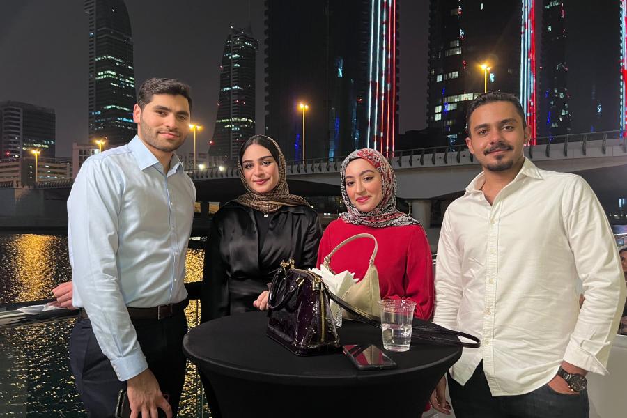 Four alumni smiling at camera during Bahrain reunion 2022