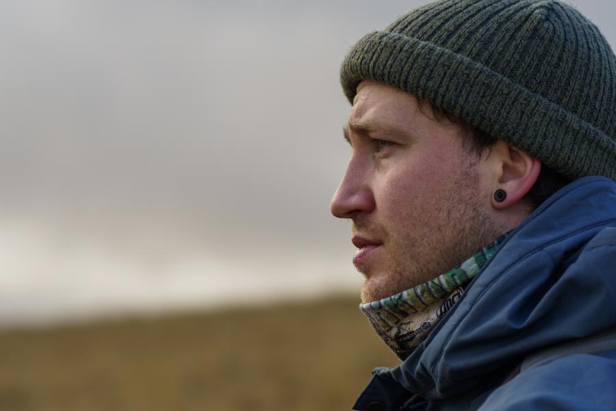 Profile image of young man wearing green beanie hat and blue outdoor coat.