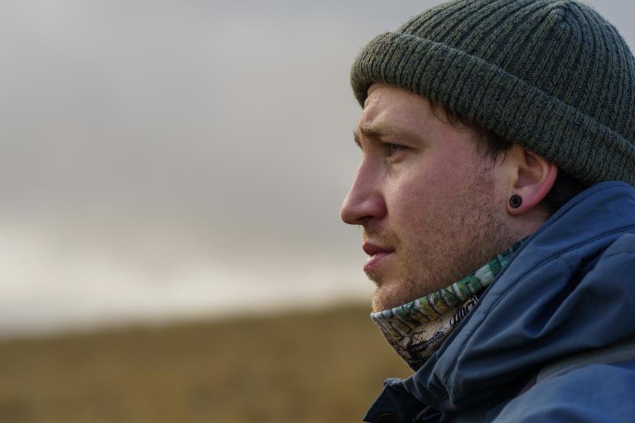 Profile image of young man wearing green beanie hat and blue outdoor coat.