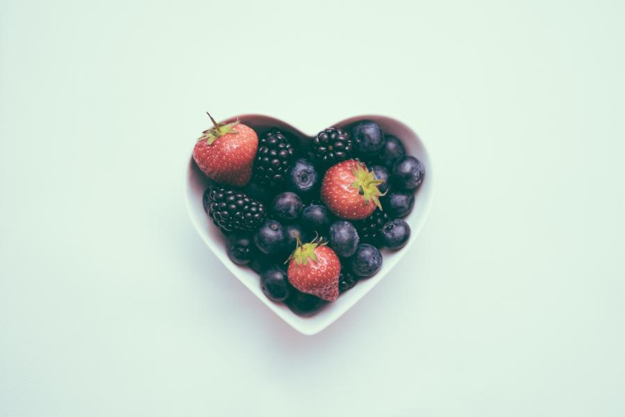 a heart shaped bowl full of fruit