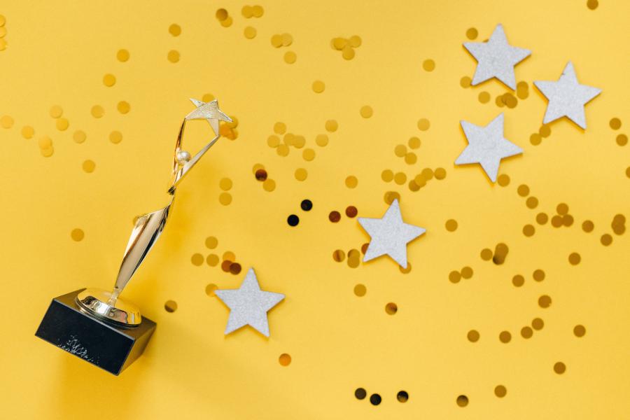 gold stars and trophy on yellow background