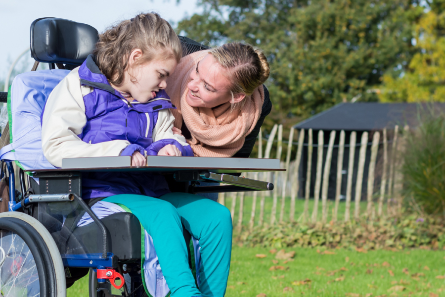 Girl in a wheelchair, with a social worker