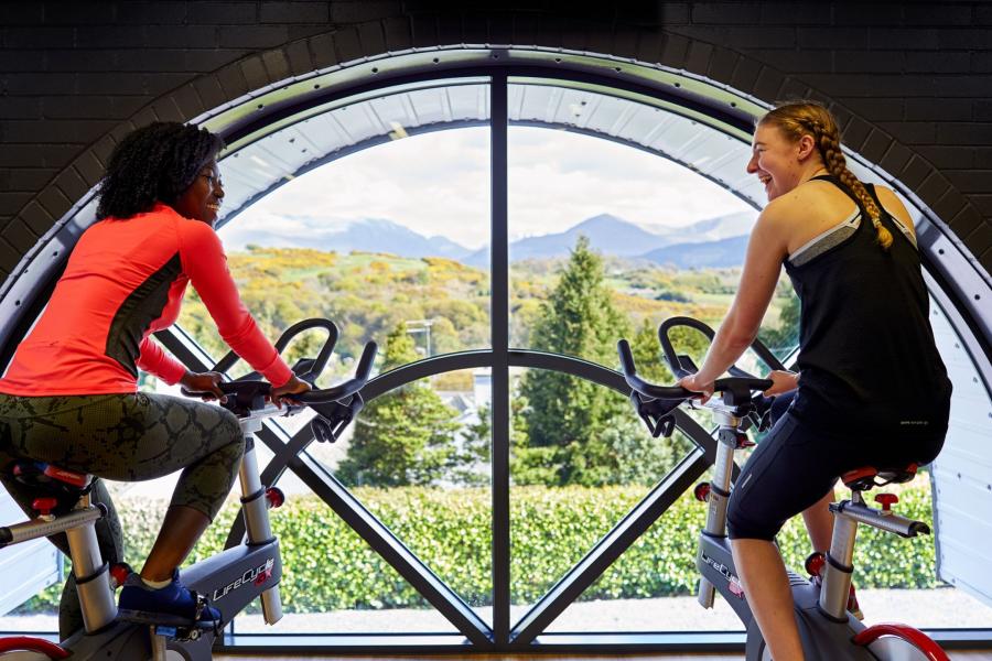 Students on exercise bikes at Canolfan Brailsford with amazing view of the mountains through the window