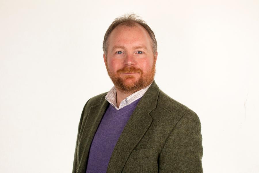 Headshot of person in blazer and shirt