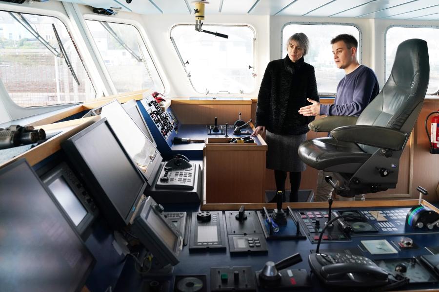 UKRI Chief Executive Professor Dame Ottoline Leyser is shown the bridge of the Prince Madog Research Vessel at the Marine Centre Wales, Anglesey, by Navigation Cadet Matthew Brown, 