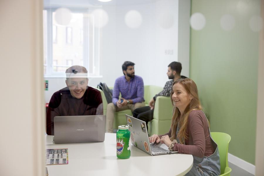Students on laptops in the kitchen area at St Mary's halls of residence