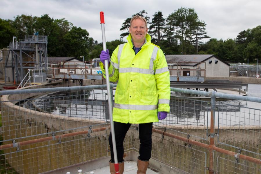 Person standing in a Water treatment plant with samples of waste water