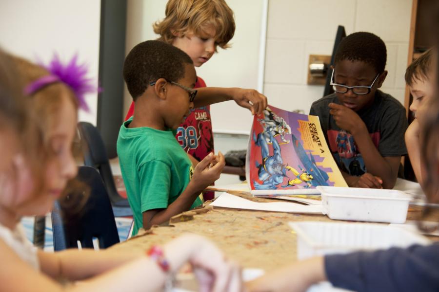 a classroom full of kids reading and drawing 