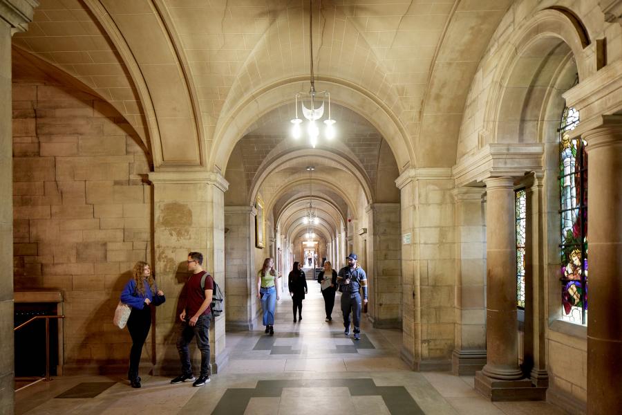 A group of students walking down the main corridor at the Main Arts building