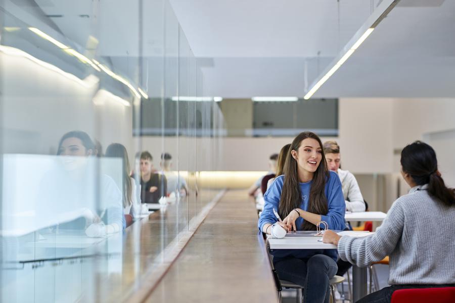 Image of a group of students sitting by a table at the Pontio learning space