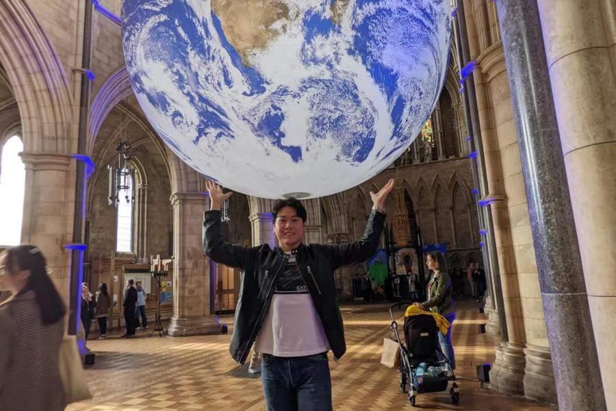 Minglin Fu holding up a globe 