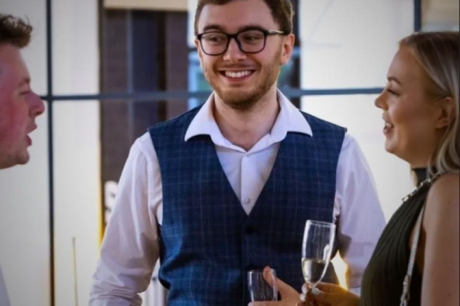 Jeremy Smith with friends chatting over a glass of prosecco 