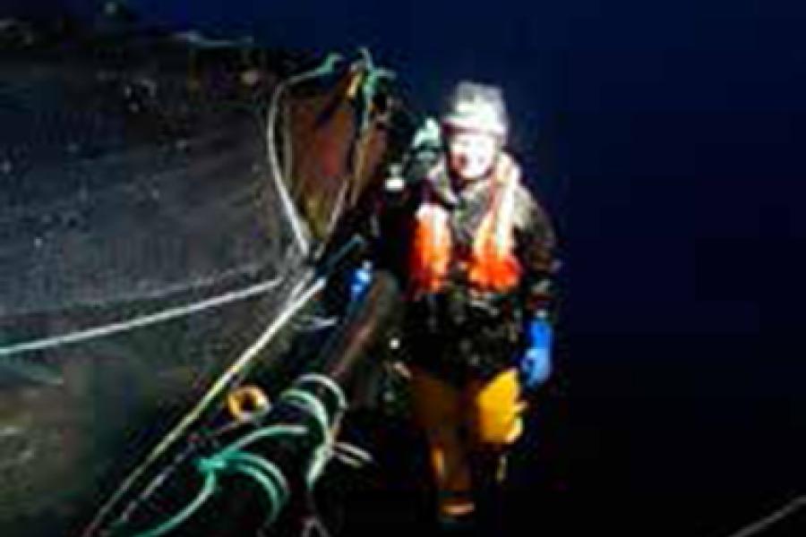 Ocean Sciences graduate, Tilly Painter Jones standing next to a pipe running in to the sea