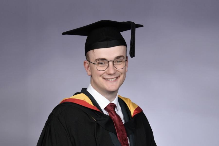 Joseph Brittan smiling to camera on his graduation 