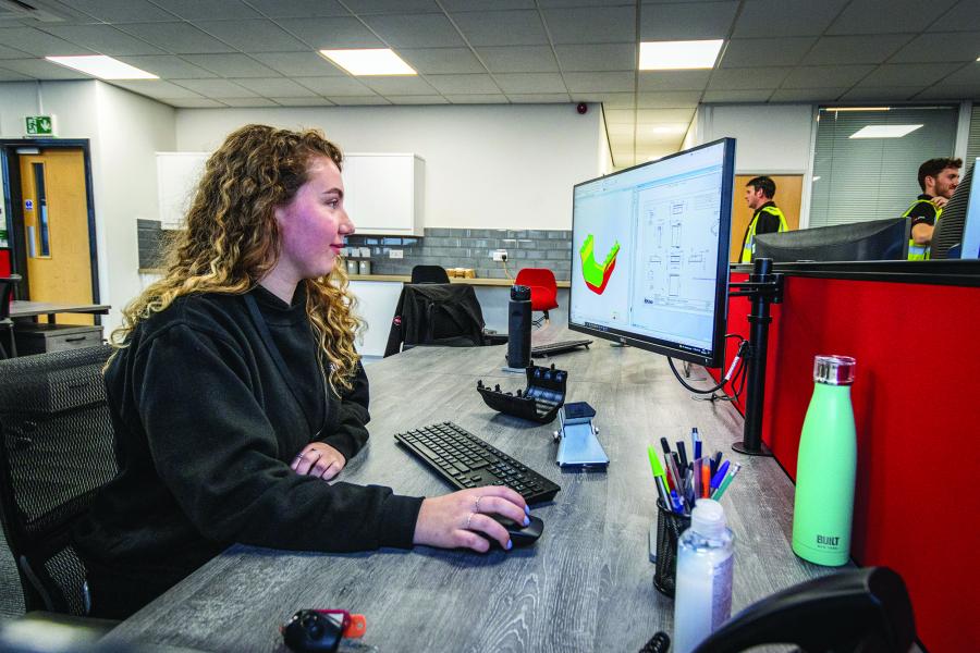 Lowri Edwards, Product Design graduate working on designs on a computer 