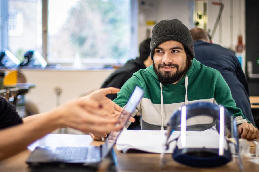 Smiling product design student working next to a table in the workshop