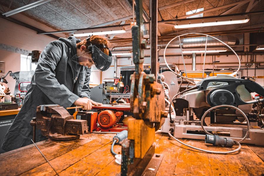 Product design student using a Hegner saw in the workshop