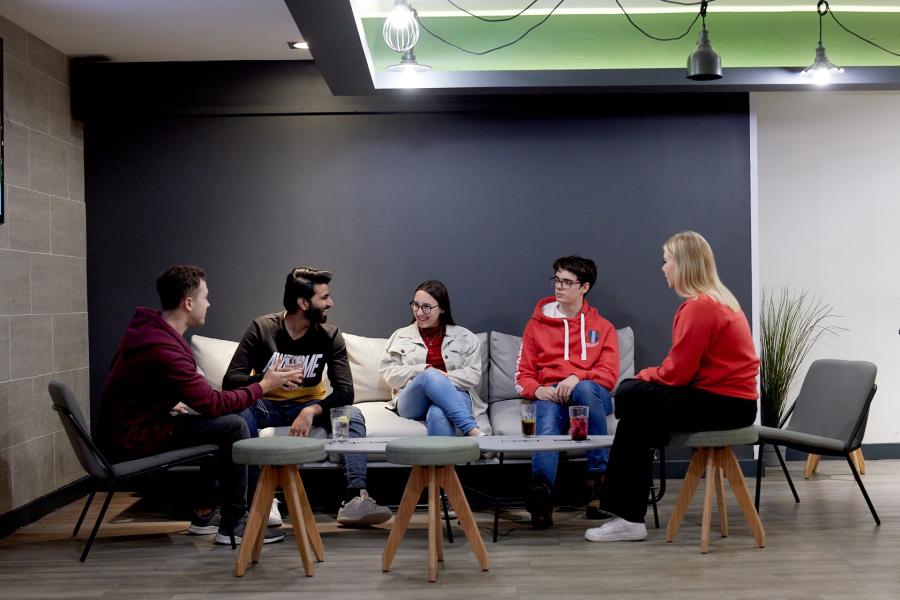 Students sitting together having a drink and socialising in Bar Uno, Ffriddoedd Village