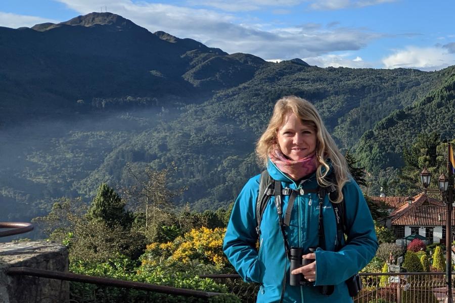 Women standing in front of forested mountains