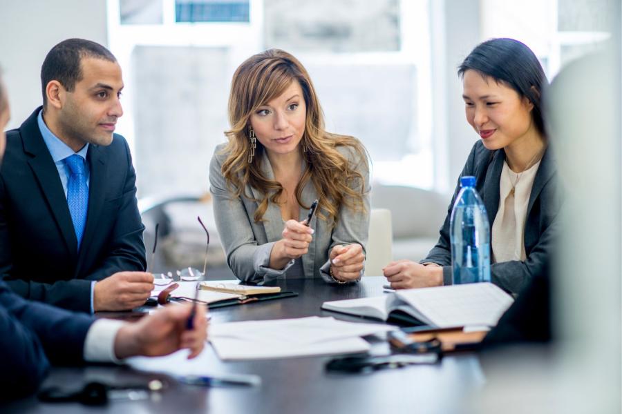 Image of business meeting with two females and one male in suit