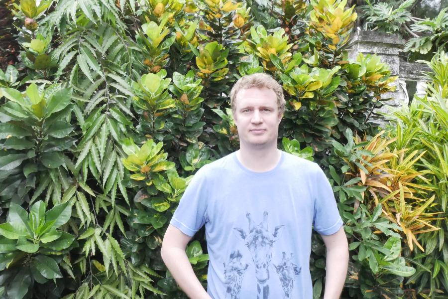 Hugh Doulton, member of Dahari staff, standing in front of greenery