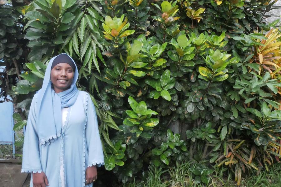 Member of Dahari staff, Nastazia Mohamadi standing in front of greenery