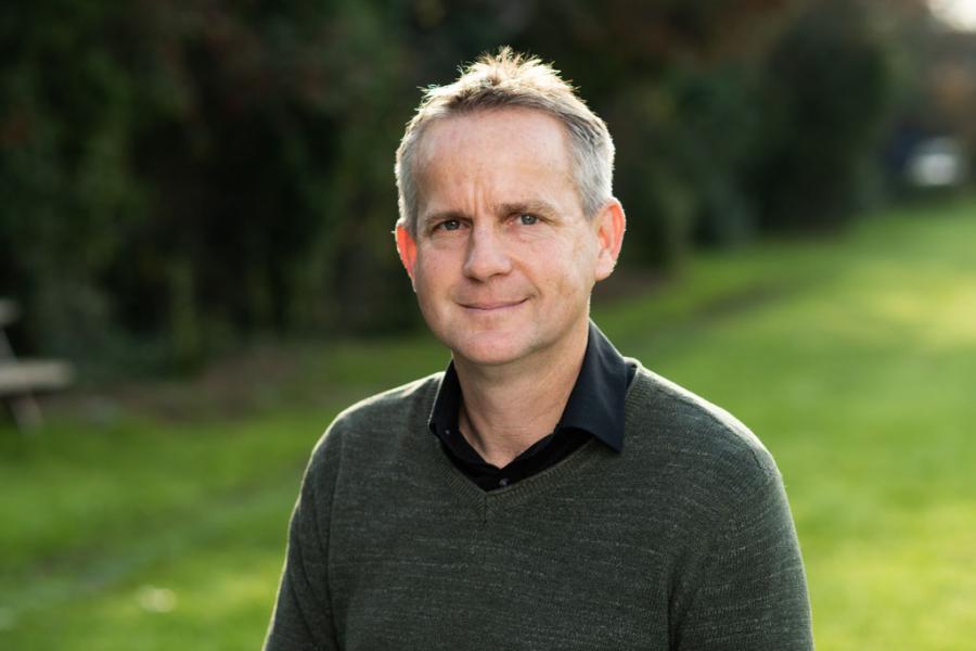 Member of Dahari staff, Owen Lewis, with blurred green grass and tress in the background