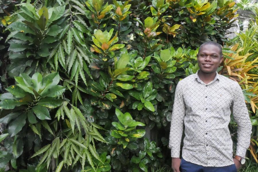 Member of Dahari staff, Salim Ibrahim, standing in front of greenery