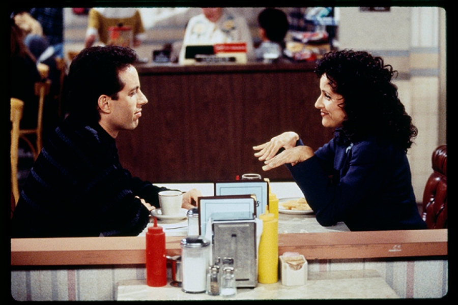 two Seinfeld characters chat in the cafe location in the show