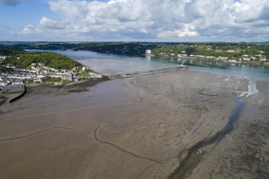 Drone image from sky looking down on sea beach and banor pier