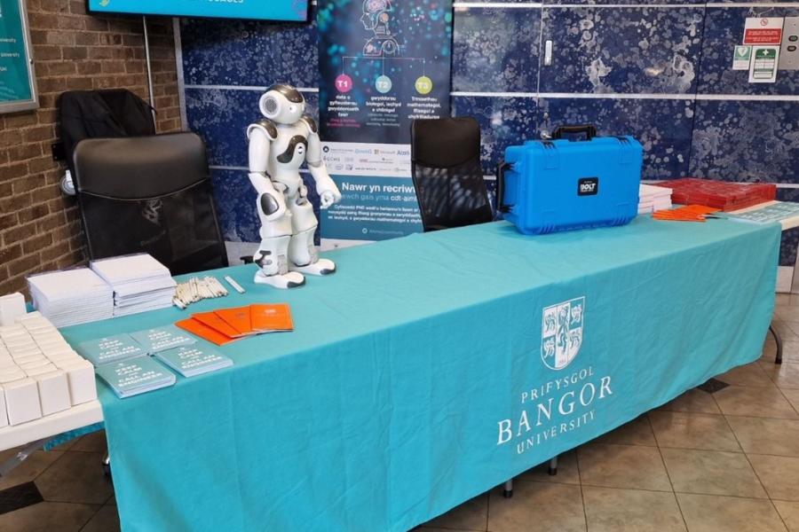 A small white robot stands on a reception desk