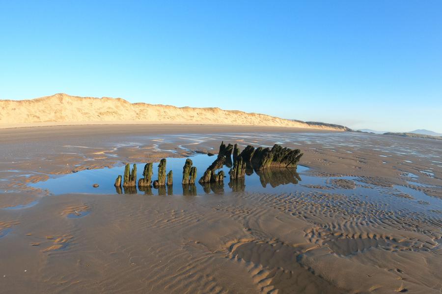 Boat remains on sandy beach 