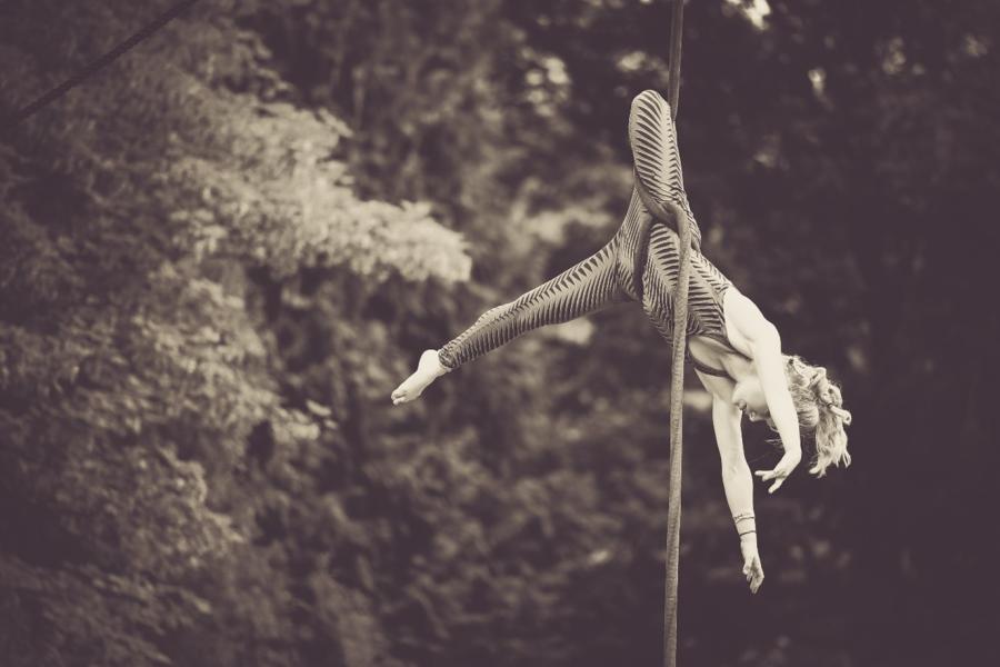 Image of a woman hanging upside down on a rope