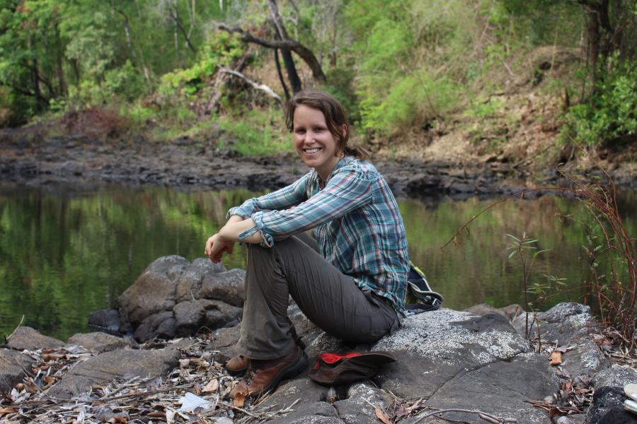 Lady sat on rocks near water