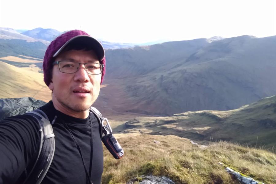 Man standing with beautiful rolling mountains behind him