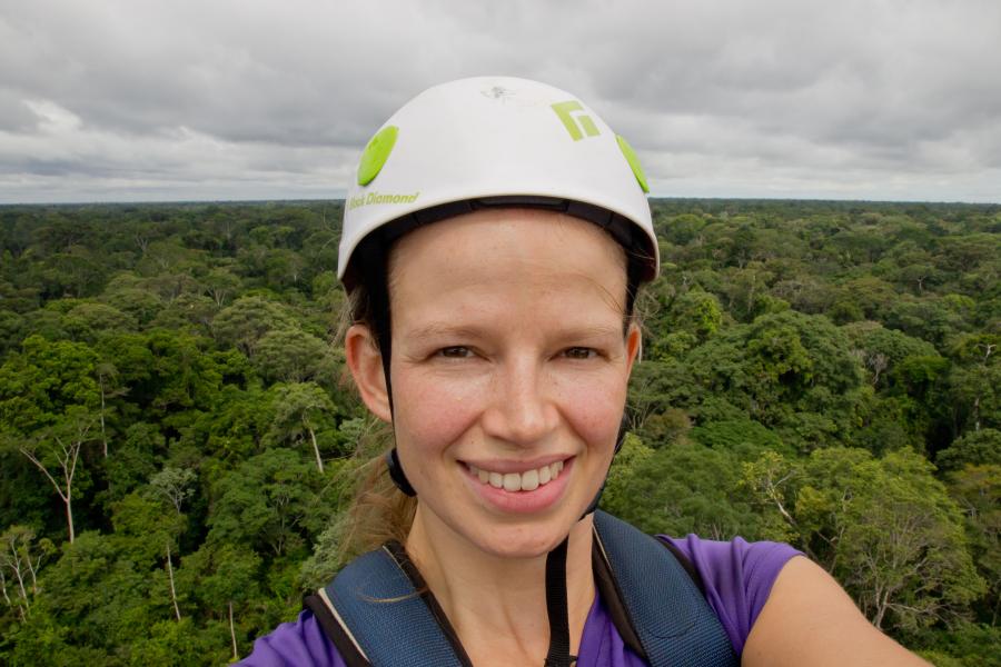 Woman in hard hat with greenery around her
