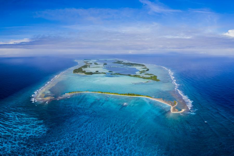An atoll sits in a blue ocean