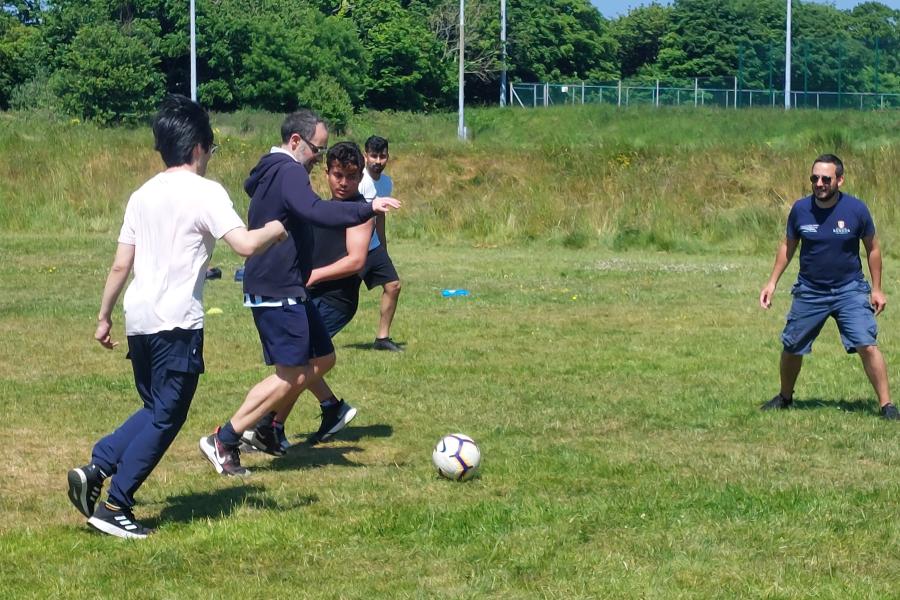 Staff and students playing football