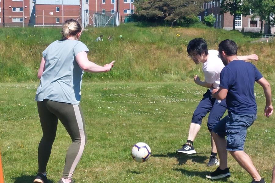 Staff and students playing football