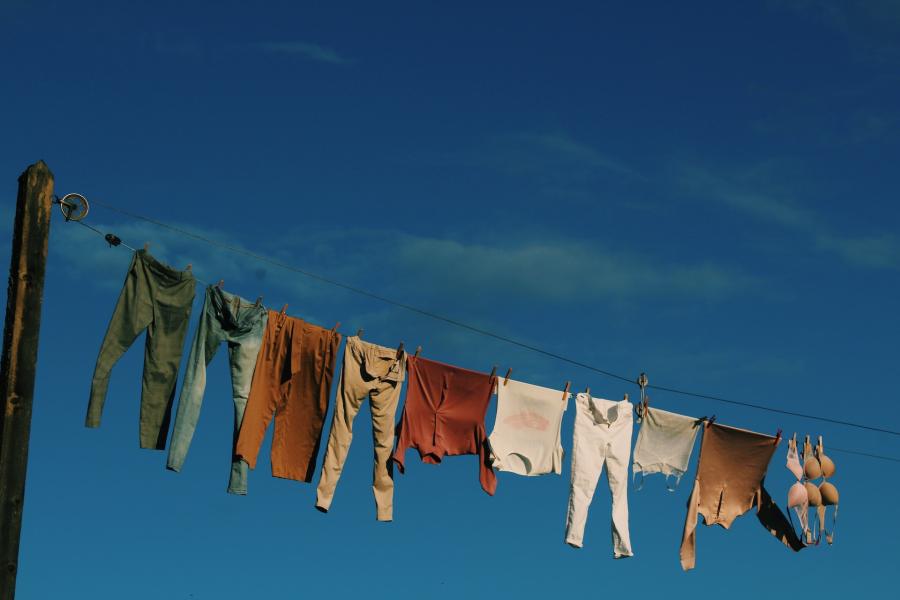 Colourful laundry drying on a washing line against a blue sky