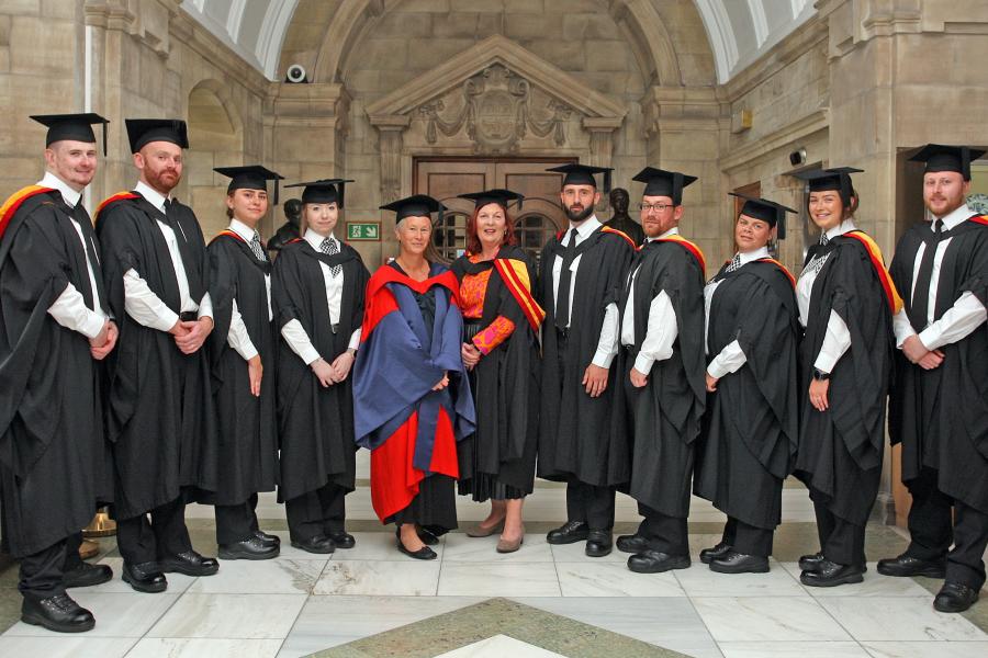 Group of graduates and academics in graduation gowns